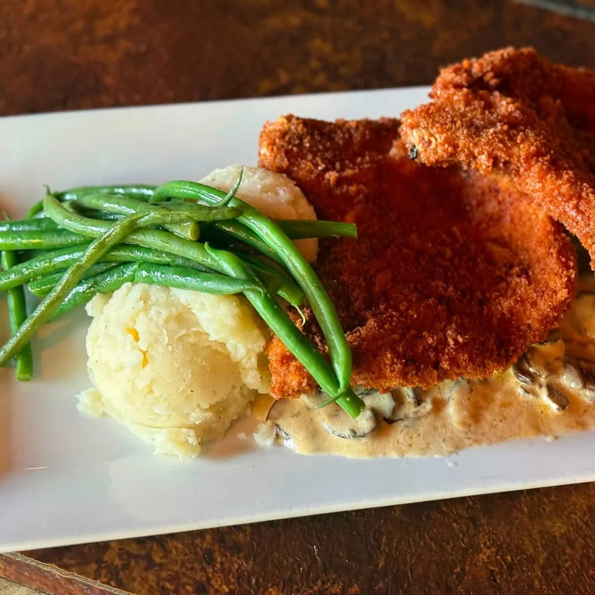 Panko-crusted pork chops over creamed cremini mushrooms with haricot vert and whipped potatoes at The Mansard Inn