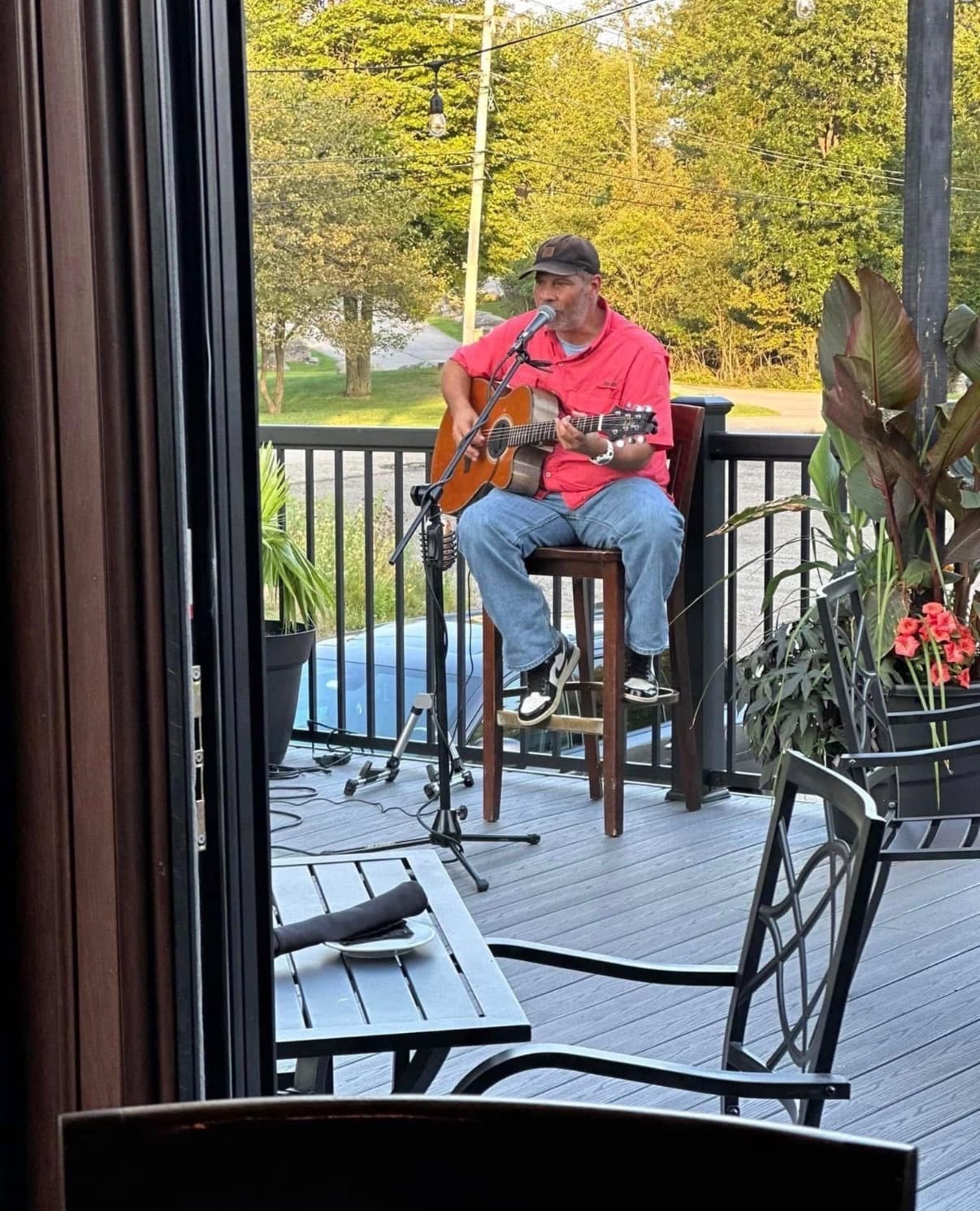 A local artist playing acoustic guitar on The Mansard Inn deck